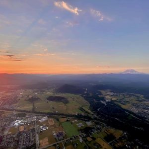 View from a Seattle Ballooning's hot air balloon ride. Sun coming over the Cascade mountains right at sunrise
