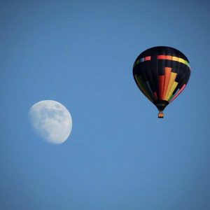 Hot air balloon flying near moon like ufo